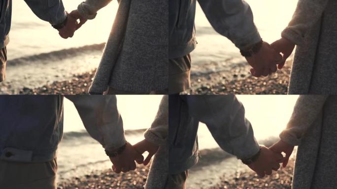 男人和女人的手的特写镜头，这对夫妇正站在海边