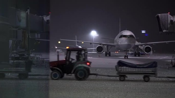 机场的暴风雪。工人和服务车在飞机附近工作