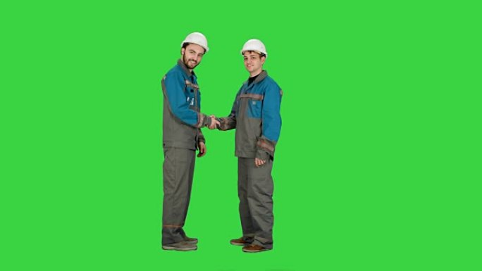 两名建筑商，建筑师在绿色屏幕上握手，色度键