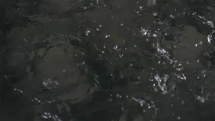 雨滴以真实的慢动作落入水池中的视频