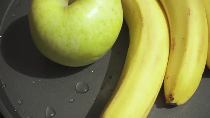 苹果和香蕉在烤盘上慢动作旋转