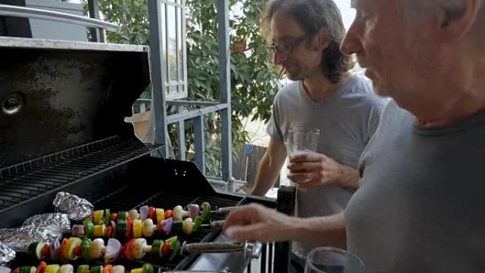 大儿子和父亲在露台外面烧烤蔬菜