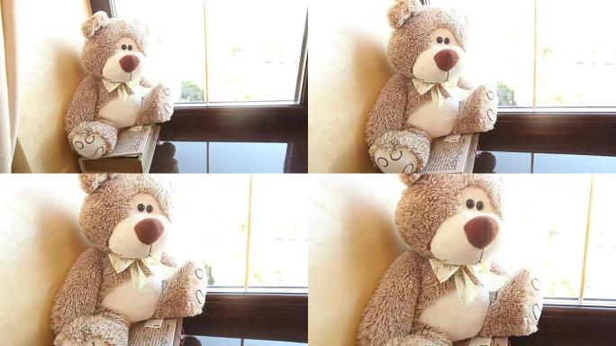 泰迪熊坐在窗台上，可爱的泰迪熊靠近窗户，脖子上有一只蝴蝶，浅棕色，儿童毛绒玩具，一只泰迪熊脖子上有一