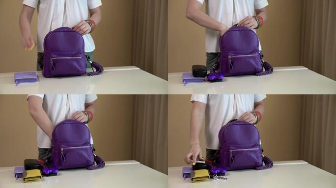 一名年轻女子拿出紫色背包里的东西，把所有的东西都放在一张白色的桌子上。女士包的内容。
