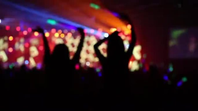 在夜间派对音乐会上跳舞的人影拥挤
