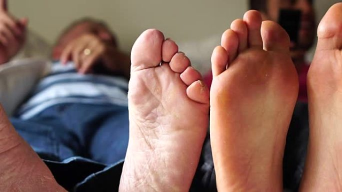 朋友/父亲和儿子在床上玩耍的Feets