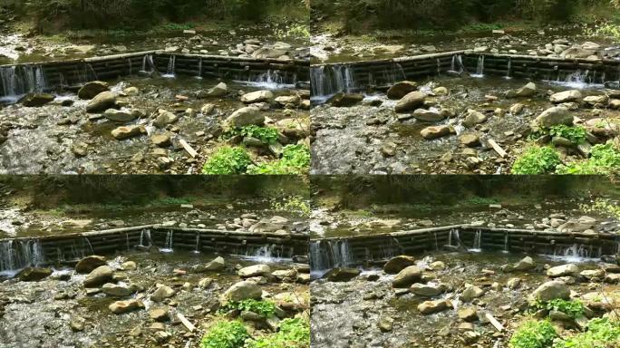 山间小河上的木坝和一堆石头。