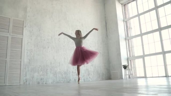 优雅的年轻芭蕾舞演员在经典的芭蕾舞短裙中跳舞，并在大窗户的背景下跳舞