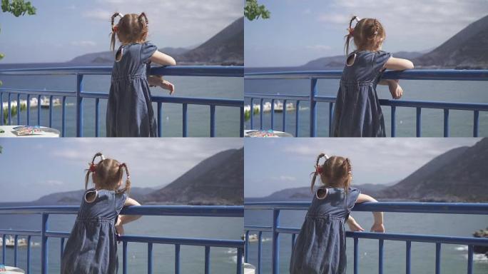 女孩站在酒店的阳台上，看着泻湖海