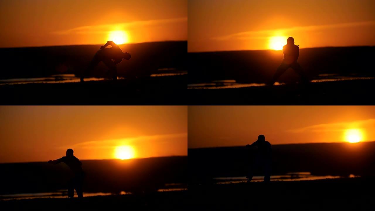 在夏季日落的山丘上，男子拳击手表演翻转的剪影
