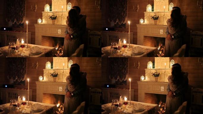 一对相爱的夫妇在壁炉附近的烛光下用餐