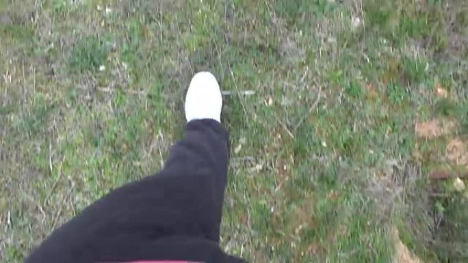 穿着白鞋的脚在田野里行走