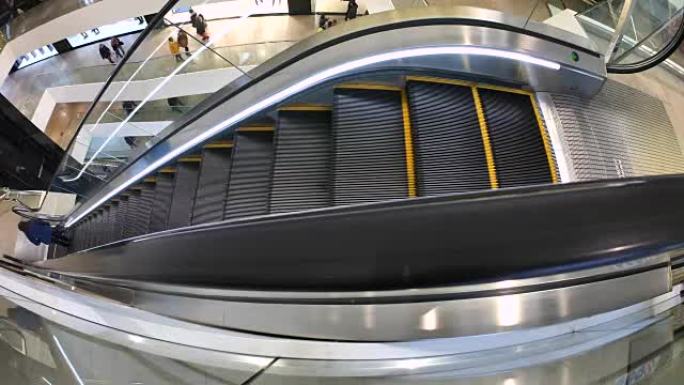 人们在商务购物中心的自动扶梯上移动。自动扶梯的移动楼梯