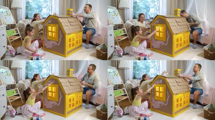 Young family with child building and painting toy 