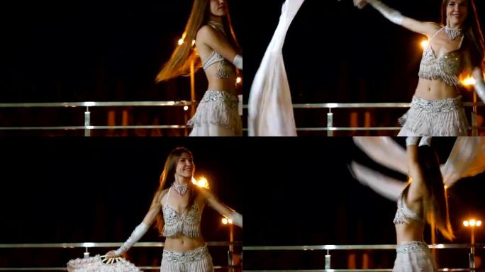 穿着东方民族服装的美丽年轻女子晚上在户外跳舞