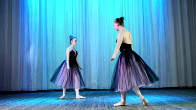 芭蕾彩排，在老剧院大厅的舞台上。年轻的芭蕾舞演员穿着淡紫色的黑色优雅连衣裙和尖头鞋，优雅地跳舞着一定