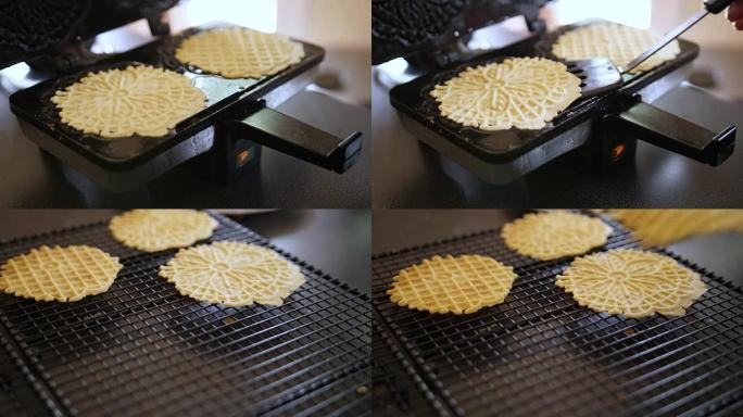 女人打开Pizzelle Maker移除两个Pizzelles