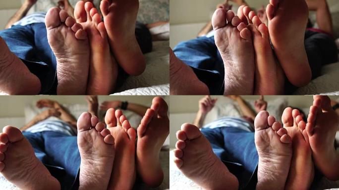 朋友/父亲和儿子在床上玩耍的Feets