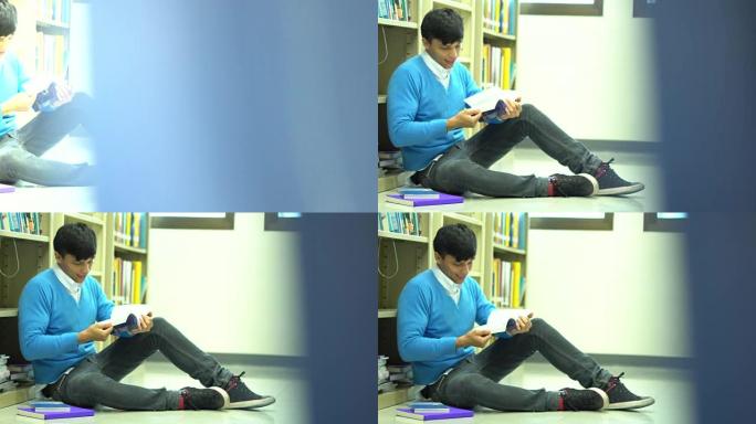 亚洲男子学生在学校图书馆看书
