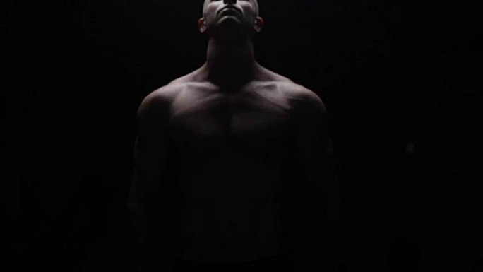 Bodybuilder posing in dark