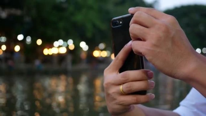 用手机自拍的人手拍摄波光粼粼的湖面