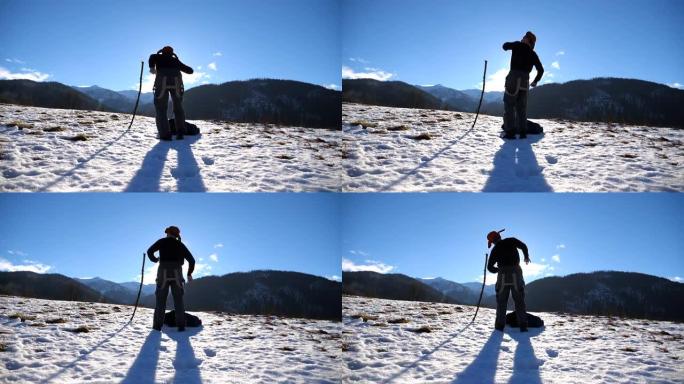 面目全非的年轻人在冬季山区跳舞滑稽。盖伊在白雪皑皑的风景背景下跳舞。男性游客在冬季大自然中玩耍。慢动