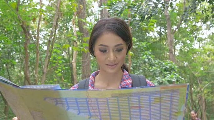 亚洲妇女在森林中看地图