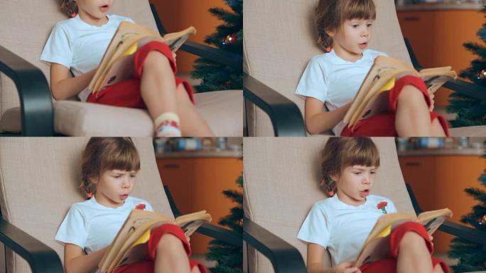Small girl reading a book in front of Christmas tr