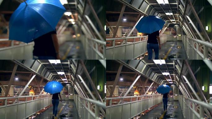 撑伞在行人天桥上行走的妇女