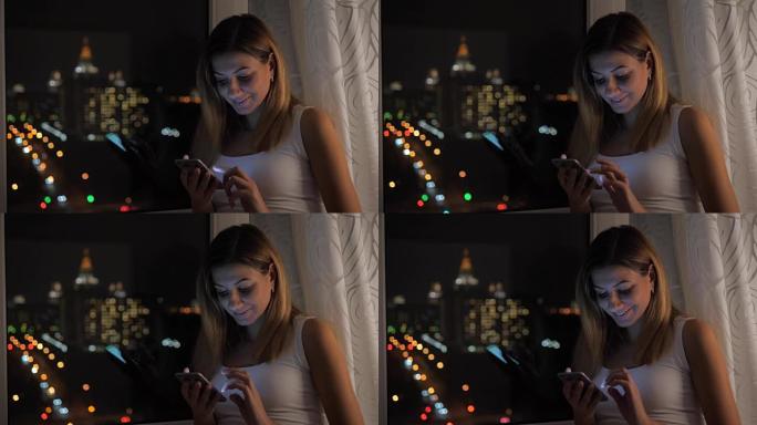 漂亮的女人站在窗前欣赏夜景，并使用智能手机