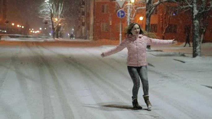 一个年轻幸福的女人在冬季城市的肖像。女孩走在街上，享受雪