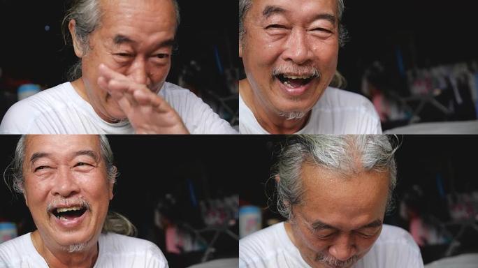 坐在地板洗衣房上的亚洲快乐老人的手持镜头慢动作。