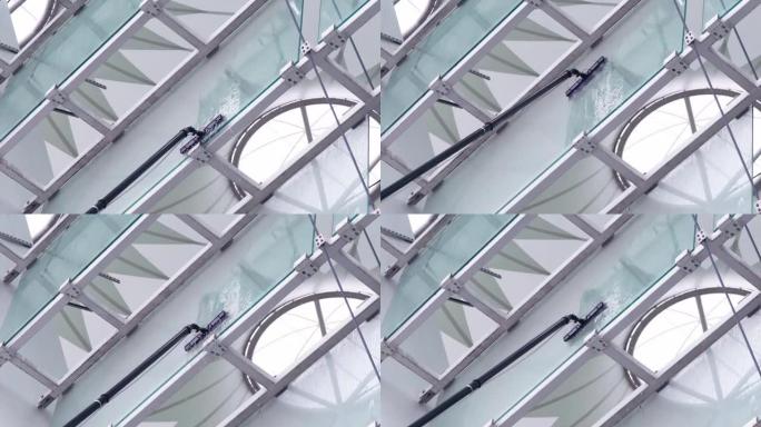 用长柄刷子清洗窗户，清洁体育场的玻璃表面，慢动作