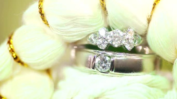 白色纤维背景下结婚戒指的宏观拍摄。
