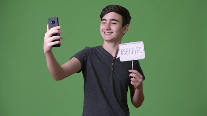 绿色背景下年轻英俊的伊朗十几岁男孩