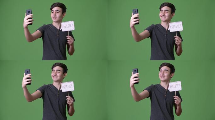 绿色背景下年轻英俊的伊朗十几岁男孩