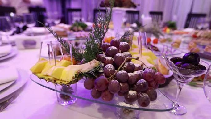 餐厅宴会桌上的水果和食物，宴会桌上的菠萝和葡萄束，宴会厅的装饰，餐厅内部