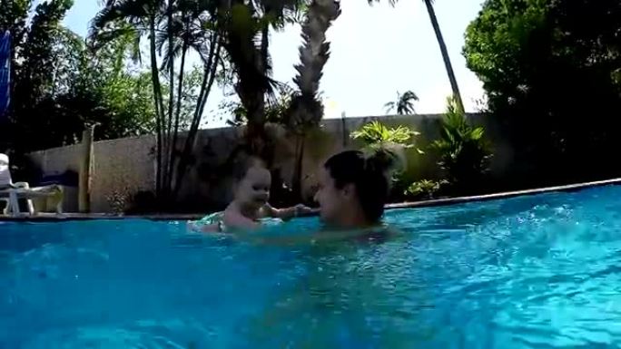Mother and baby in swimming pool in summer time