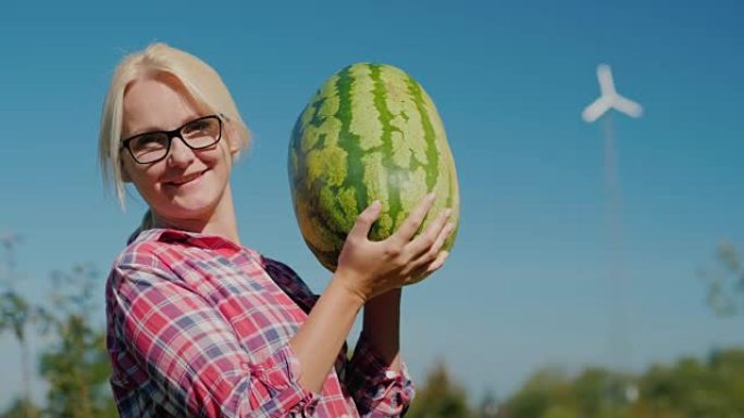 巨大的水果。一个大西瓜的女人看着镜头