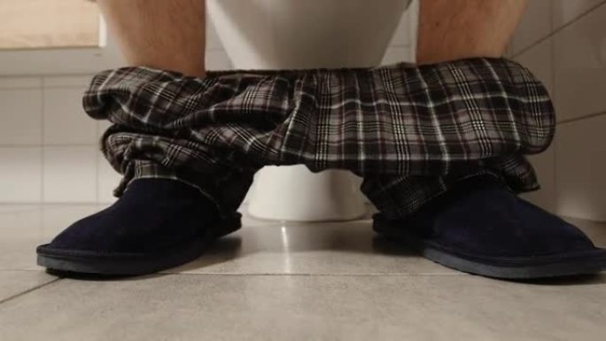 厕所附近穿着睡衣和拖鞋的男性腿的特写镜头-他脱下衣服