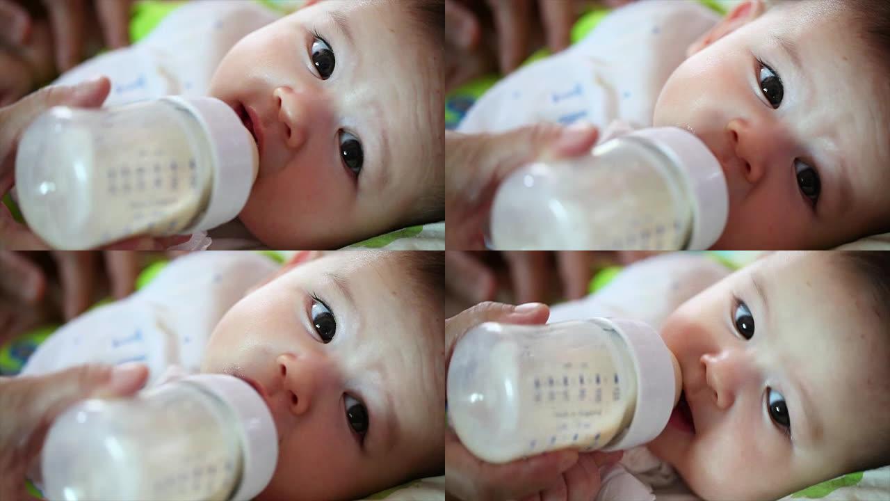 漂亮的男婴喝奶瓶里的牛奶