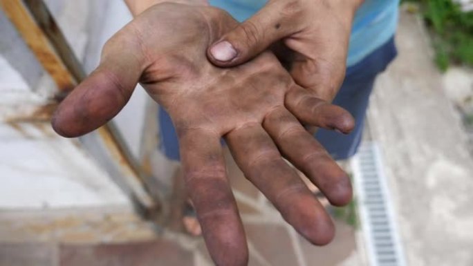 面目全非的年轻机械师下班后摩擦脏手。关闭慢动作顶视图