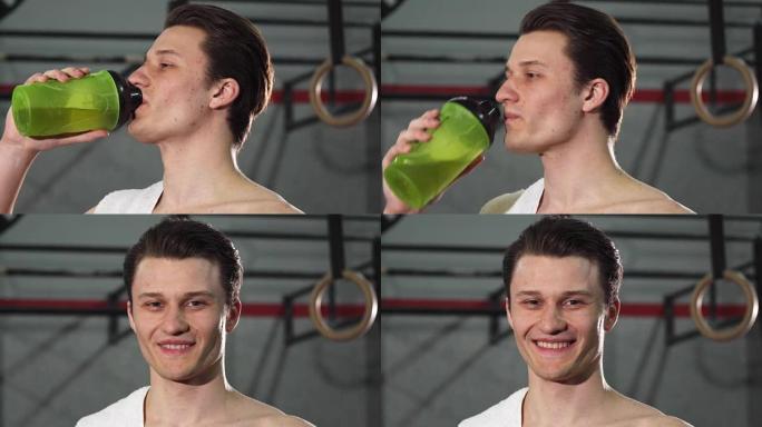 一个年轻的男运动员微笑着愉快地喝水的特写