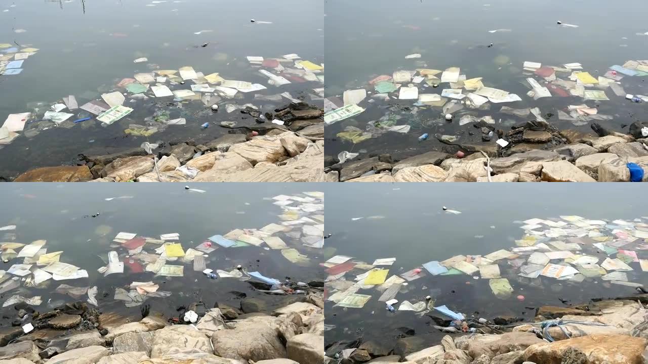 环境污染。河或湖中的塑料瓶、袋子、垃圾。漂浮在水中的垃圾和污染。沿着受污染的海岸运动。特写