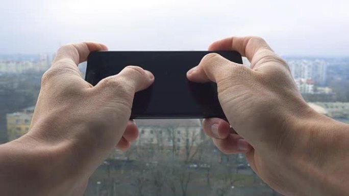 男子在智能手机上发短信反对城市景观的特写镜头