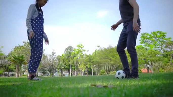 年轻女孩和父亲踢足球