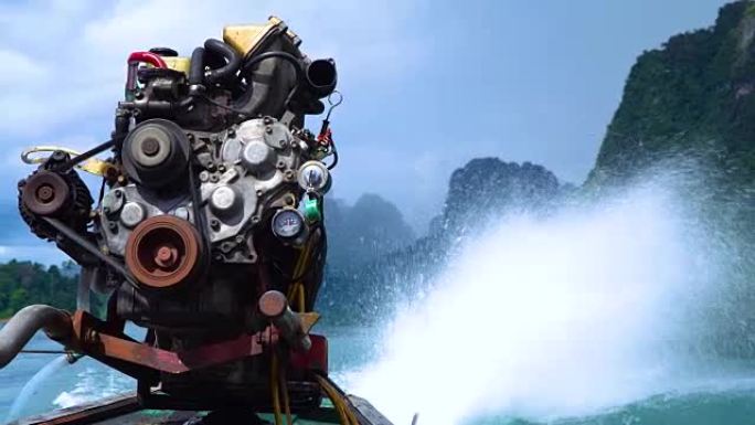 泰国长尾船上发动机的特写镜头和螺旋桨的喷雾。
