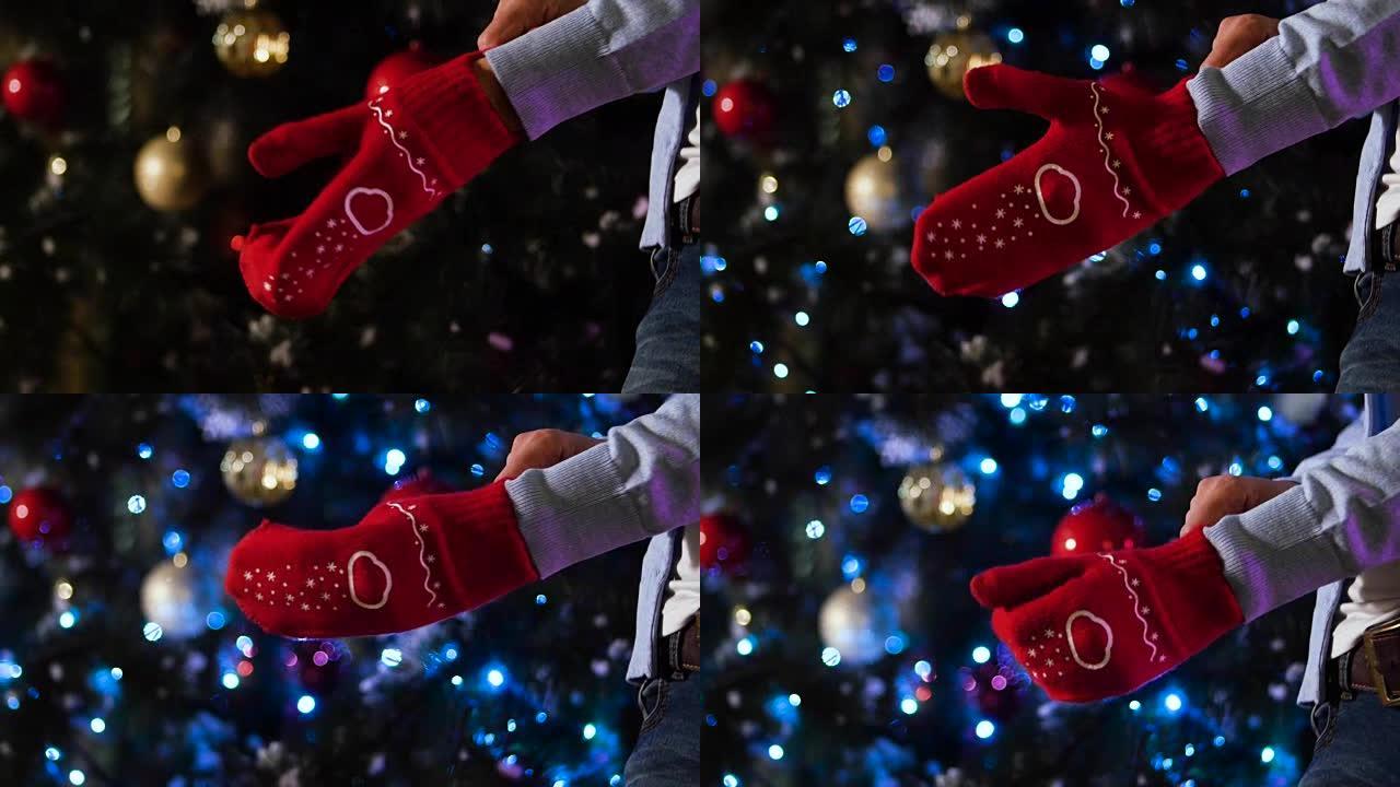 在圣诞节背景下，用红色羊毛手套散开手，冬天的欢乐概念。男子手里戴着圣诞手套