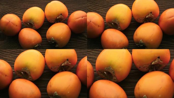 木制桌子上的新鲜橙色柿子。美味的橙色柿子。