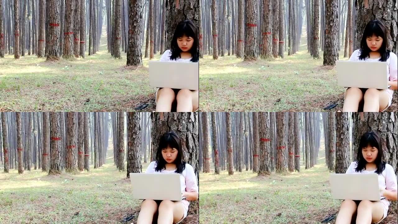 十几岁的女孩在公园里成功地使用笔记本电脑。